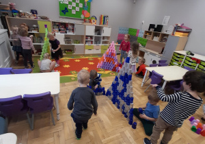 Dzieci układają wieże z plastikowych kolorowych kubeczków.