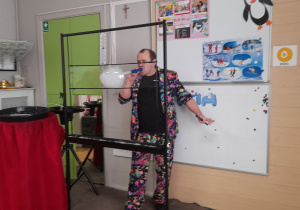 Pan Bańka prezentuje swoje umiejętności, rozdmuchuje bańki z dymem.